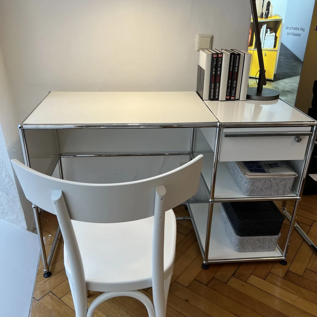 Modular steel desk with a drawer module and open shelving in a home office